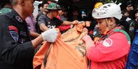 epa10319437 Indonesian policemen and rescue personnel evacuate the body of a victim from a landslide caused by a 5.6 magnitude earthquake, in Cianjur, Indonesia, 22 November 2022. The earthquake hit the southwest of the Cianjur District in West Java Province has left at least 103 people dead, according to the Indonesia's National Disaster Management Authority.  EPA-EFE/ADI WEDA