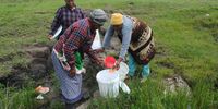 Mancam villagers use a small strainer to catch fungi, worms and other debris found in the murky spring water they rely on. (Photo: Mkhuseli Sizani)