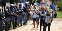 Wits University students offer flowers to police officers in a gesture of non-violence during the #FeesMustFall protests on 4 October 2016 in Johannesburg. (Photo: Gallo Images / Beeld / Felix Dlangamandla)