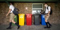 Students walk past waste &amp; ecobrick collection bins at the DF Malan high school in Belville, Cape Town. (Photo by David Harrison)