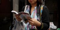 A tourist consults her guide book in the street in the Soho area of the City of Westminster on August 19, 2010 in London, England. (Photo by Oli Scarff/Getty Images)