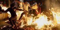 People pull a cow over a bonfire as part of the Makara Sankranthi or Pongal festival celebrations in Bangalore, India, 14 January 2025. Cows and bulls are decorated with bright colors during the Hindu festival of thanksgiving, celebrated after the harvesting season.  EPA-EFE/JAGADEESH NV
