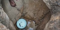 A girl is reflected as she leaps into a hand-dug well to draw water on November 22, 2020, near Luveve in Bulawayo, Zimbabwe. Several people have had minor injuries while drawing water from the wells. (Photo: Zinyange Auntony)