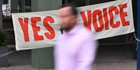 A person walks past a banner during early voting for the Indigenous Voice to Parliament referendum in Canberra, Australia, 03 October 2023. Early voting began for the referendum on a reform which, if approved, would create an indigenous body able to advise the Australian Parliament on issues affecting Aboriginal and Torres Strait Islander people.  EPA-EFE/MICK TSIKAS AUSTRALIA AND NEW ZEALAND OUT