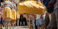A resident, wearing a traditional costume and walking on stilts, takes part in a 'colorful dance' down a slope as part of a festival called 'The Anguiano Dancers' in Anguiano, La Rioja, northern Spain, 22 July 2024. The dancers walk down a slope, turning like a human spinning top onto 45-centimeter-high stilts to worship the town's patron, Mary Magdalene, in a tradition dating back to 1603.  EPA-EFE/RAQUEL MANZANARES