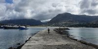 Lone cyclist exploring a moody Hout Bay Harbour, Cape Town. Image: Alastair Mackie
