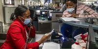 A woman tries to get assistance following the cancellation of her flight to London at OR Tambo International Airport, Gauteng, on 26 November 2021.<br>(Photo: Shiraaz Mohamed)