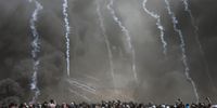 epaselect epa06736016 Israeli army fire tear gas grenades at Palestinian protesters during clashes after protests near the border with Israel in the east of Gaza Strip, 14 May 2018. According to media reports, at least 41 Palestinians were killed and more than 1800 wounded during clashes in Gaza-Israeli border during clashes against the US embassy move to Jerusalem as well as marking Nakba Day. Palestinians are marking the Nakba Day, or the day of the disaster, when more than 700 thousand Palestinians were forcefully expelled from their villages during the war that led to the creation of the state of Israel on 15 May 1948. Protesters call for the right of Palestinians to return to their homeland.  EPA-EFE/MOHAMMED SABER
