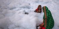 DELHI, INDIA - NOVEMBER 10: Hindu devotees take a dip in the waters of River Yamuna amid toxic foam caused by pollution on the occasion of  Chhat puja on November 10, 2021 in Delhi, India. (Photo by Anindito Mukherjee/Getty Images)