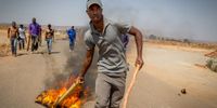 Angry community members burn tyres and blockade roads during protest against land eviction by South African Police Forces and members of the private Red Ants, in Unaville, Johannesburg, South Africa, 22 September 2017. (PHOTO: EPA-EFE/STR)
