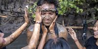  Balinese people cover their bodies with mud during the mud bathing tradition locally known as 'Mebuug Buugan', in Badung, Bali, Indonesia, 12 March 2024. Mebuug Buugan is a form of gratitude for the fertility of the earth and is also believed to neutralize spiritual negativity. This tradition is practiced by all members of the Kedonganan village community, both men and women, adults and children.  EPA-EFE/MADE NAGI
