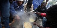 Sub-Saharan African migrants eat at a makeshift camp outside the International Organisation for Migration (IOM) headquarters in Tunis, Tunisia, 18 December 2023. International Migrants Day is observed annually on 18 December to raise awareness about the issues faced by migrants around the world as the effects of climate change, conflict, and insecurity forces people to move within countries or across borders, according to the UN migration agency IOM.  EPA-EFE/MOHAMED MESSARA
