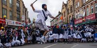 A Sikh devotee demonstrates sword fighting techniques during the Nagar Kirtan procession on April 7, 2024 in Southall, England. The Nagar Kirtan procession takes place during the festival of Vaisakhi which celebrates the spring harvest, primarily in Punjab and Northern India. Traditionally, Nagar Kirtan is led by the Panj Piare (the five beloved of the Guru), who are followed by the Sikh holy scripture, which is placed on a float. Participants in the procession are often shoeless in deference to the displayed scripture while the road before the procession is cleared by Sewadars. (Photo by Carl Court/Getty Images)
