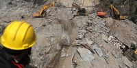 epa09960437 Rescue workers run for cover as earth movers dig through rubble of a collapsed tunnel in Ramban district, south of Srinagar, the summer capital of Indian Kashmir, 20 May 2022. According to the government official in disaster management department, 10 workers were trapped after part of a tunnel collapsed.  EPA-EFE/FAROOQ KHAN