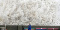 LIVERPOOL, ENGLAND - FEBRUARY 17: People view the waves created by high winds and spring tides hitting the sea wall at New Brighton promenade on February 17, 2022 in Liverpool, England. A red alert has been declared for Storm Eunice which is arriving in the early hours of Friday in the wake of Storm Dudley. (Photo by Christopher Furlong/Getty Images)