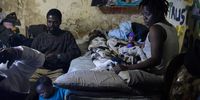 A family as seen in their tiny room on the basement level.<br>Photo / Shiraaz Mohamed