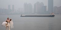 Newlyweds take wedding photos during a hazy day nearby the Yangtze river on January 19, 2022 in Wuhan, Hubei Province, China. (Photo by Getty Images)