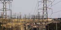 Electrical power lines hang from transmission pylons above houses in Soweto, South Africa, on Tuesday, Aug. 8, 2019. Eskom Holdings SOC Ltd., South Africas biggest polluter, said emissions of particulate matter that cause chronic respiratory disease are at their highest level in two decades as the state power utilitys financial meltdown has seen it skip maintenance and has triggered strikes. Photographer: Waldo Swiegers/Bloomberg via Getty Images