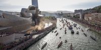 Dozens of boats pass by the Guggenheim Museum as they sail along Nervion estuary during the Spanish King's Cup trophy parade aboard the popular 'Gabarra' (barge), in Bilbao, Spain, 11 April 2024. Bilbao beat Mallorca on 06 April on penalties to win the Copa del Rey for the first time in 40 years and the team is sailing down the Nervion river on a barge as they did in 1984.  EPA-EFE/Miguel Tona