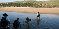 Hikers cross a section of the Mtentu River to reach the northern section of Mkambati Nature Reserve.