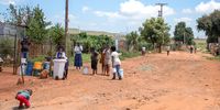 Residents of the Phumla Mqashi informal settlement in Lenasia South return home with buckets of water filled from JoJo tanks, following the disconnection of illegal water connections. (Photo: Julia Evans)
