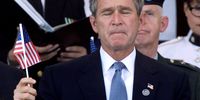 U.S. President George W. Bush holds an American flag during a Memorial Service at the Pentagon October 11, 2001 in Arlington, Virginia.  (Photo by Mark Wilson/Getty Images)