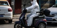 WUHAN, CHINA - FEBRUARY 05: A resident wears a protective mask while riding a scooter on February 5, 2020 in Wuhan, Hubei province, China. Flights, trains and public transport including buses, subway and ferry services have suffered disruption for two weeks.  (Photo by Getty Images)