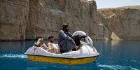 BAND-E-AMIR, AFGHANISTAN - AUGUST 12:  Taliban members paddle in a boat as they and Afghan families enjoy a visit to one of the lakes in Band-e Amir national park, a popular week-end destination, on August 12, 2022 in Band-e Amir, Bamyan province of Afghanistan. The collapse of the economy and the freezing of Afghan and donor funds after the Taliban takeover of the country in August 2021 created a humanitarian crisis. Most art, culture and pastimes have been banned. The female population have also had to quit jobs and young girls after the age of 12 can no longer go to school or complete further education. (Photo by Nava Jamshidi/Getty Images)
