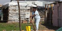 A woman collects water from a tap in Majoks,Swellendam. (Photo: Shelley Christians)