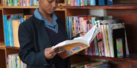 One of the Zingisa Comprehensive High School pupil Dinga Lubala reading a book inside the Library donated at the school on 18 July 2023 (Photo: Hoseya Jubase)