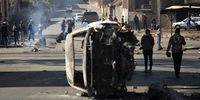 A burnt car at a road block in downtown Johannesburg. (Photo: EPA-EFE / KIM LUDBROOK)