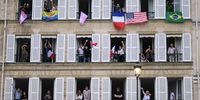 PARIS, FRANCE - JULY 26: Spectators with various international flags cheer from balconies as photographed from Brazil's delegation boat sailing along the river Seine during the opening ceremony of the Olympic Games Paris 2024 on July 26, 2024 in Paris, France. (Photo by Carl de Souza-Pool/Getty Images)