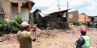 Bongani Albertus and Helen Tshabalala looks at houses damaged by floodwaters in Alexandra.(Photo: Felix Dlangamandla)
