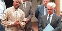 South African President Nelson Mandela (L) addresses the media after his meeting with General Constand Viljoen (R), leader of the rightwing Afrikaner Freedom Front and members of South African Afrikaner Agricultural Union at Mandela's residence in Johannesburg 28 November 1997. Mandela and farmers met to discuss the recent spate of criminal attacks in the farming community. (Photo by WALTER DHLADHLA / AFP)
