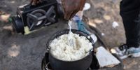 One of the homeless people living on Sydney Street cooking pap as their meal for the day. (Photo: Ashraf Hendricks)