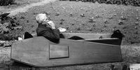 12th June 1958: Archie Miller drinking a cup of tea in the solid oak coffin he bought to ensure he would leave this world in real style.    (Photo by Chris Ware/Keystone Features/Getty Images)