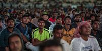 epa10318787 People, among them migrant workers, watch the FIFA World Cup Qatar 2022 match between England and Iran at the free-entry Industrial Area Fan Zone in the Asian Town Cricket Stadium, in Doha, Qatar, 21 November 2022.  EPA-EFE/MARTIN DIVISEK