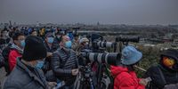 epa09591422 People wearing face masks stand at a viewpoint of Jingshan Park with their photo cameras as they wait for the partial lunar eclipse, which was not visible from the viewpoint, in Beijing, China, 19 November 2021. This was the longest partial lunar eclipse in five hundred and eighty years, giving the moon reddish hues and appearing in North America, parts of South America, Asia and Australia.  EPA-EFE/ROMAN PILIPEY