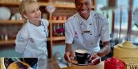 Azi Ngcobo demos some of what he learned during barista training two weeks previously. Inset: Served with a fresh flower biscuit. (Photo: Wanda Hennig)<br>