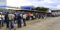 Passengers wait for their bus in Harare, Zimbabwe, 23 April 2020. (Photo:  EPA-EFE/AARON UFUMELI)