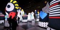 Visitors look at 'Checkmate,' a large inflatable chess set on display at 'River of Light,' an illuminated outdoor art trail in Liverpool, Britain, 24 October 2024. The exhibition trail features 12 large-scale light installations based on the theme of 'play.'  EPA-EFE/ADAM VAUGHAN