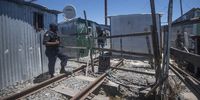 A Prasa Protection Services official inspects an informal settlement on the Central Line in Philippi, Cape Town. (Photo: Brenton Geach)