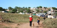 Resident carries a water bottle along a dirt road in Valencia in Sundays River Valley.
