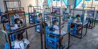 ALAMINOS, PHILIPPINES - NOVEMBER 15: Elementary students sit inside dividers as preventive measure against COVID-19, as they attend the first day of physical classes at Longos Elementary School on November 15, 2021 in Alaminos, Pangasinan province, Philippines. After almost two years since schools closed due to the COVID-19 pandemic, the Philippines resumed limited face-to-face classes in 100 schools across the country on November 15. The Philippines is the last country in the world to reopen schools since the pandemic began, after Venezuela reopened schools on October 25. Critics are blaming the government's lackluster pandemic response for the prolonged closure of schools. (Photo by Ezra Acayan/Getty Images)