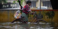 CHENNAI, INDIA - NOVEMBER 10: A man pushes a bicycle on a flooded street on November 10, 2021 in Chennai, India. As the world was discussing the effects of unseasonal rain and distress to coastal communities amongst a host of ecological issues at COP26 in Glasgow, the southern Indian city of Chennai is being battered by rain leading to massive flooding and loss of life and property. The rain and floods are reminiscent of another devastating flood Chennai witnessed in 2015 that killed over 500 people and resulted in property damage of over $3billion. (Photo by Abhishek Chinnappa/Getty Images)
