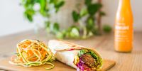 The falafel wrap is filled with beetroot hummus, avocado, cherry tomatoes, Mexican black beans, kale and red cabbage.