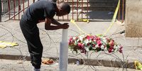 A mourner lights a candle and lays flowers at the the scene of the deadly 31 August Marshalltown fire in Johannesburg. (Photo: Felix Dlangamandla)