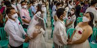 MANILA, PHILIPPINES - FEBRUARY 13: Couples take part in a mass wedding ceremony a day before Valentines Day on February 13, 2022 in Quezon city, Metro Manila, Philippines. The Philippines has eased restrictions this month as daily cases of COVID-19 gradually drop. The country has so far recorded more than 3,630,000 infections of the coronavirus, reporting more than 54,000 deaths. (Photo by Ezra Acayan/Getty Images)