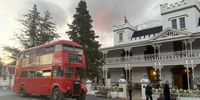 The red London bus pulls up at the Lord Milner Hotel after its evening tour. (Photo: Tony Jackman)<br>