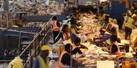 Employees of the Kraaifontein Integrated Waste Management Facility in Cape Town pick recyclables off of a conveyer belt. The facility sorts through approximately 1 500 tons of waste per month. (Photo: Tessa Knight)
